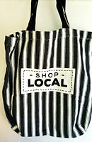 Close-up of striped cotton tote bag with 'Shop Local' patch