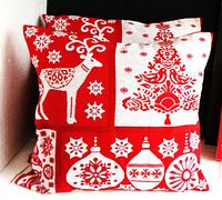 Two red and white Christmas tapestry cushions with reindeer and tree and ornament designs, 16x16 inches