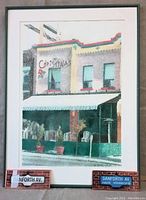 Framed drawing showing two-story Christina's restaurant with awning and building facade in pointillism style.