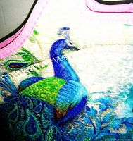 Close-up of colorful insulated lunchbag with detailed peacock design and pink trim.