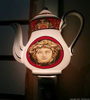 Ceramic teapot night light with detailed painted face and red, white, black ornamentation