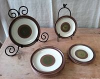 Plates displayed on metal stands to show front design of green and brown pattern, mid-century modern style