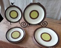 Set of Denby Potter's Wheel plates in yellow and brown glaze, 5 dinner plates and 3 salad plates arranged on a wooden surface.