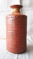 Front and side view of the cylindrical ceramic vase with textured markings, reddish-brown with flared rim.
