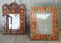 Two hand painted frames shown side by side: mirror frame with intricate geometric floral design and Kashmiri picture frame with colorful birds and floral pattern.