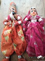 Two large Rajasthani puppets lying side by side showing full body and fabric details