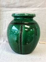Front view of a green glazed ceramic vase showing bright green color and raised vertical patterns.
