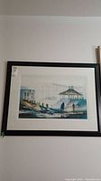 Full view of the signed framed art print showing coastal scene with waterfront buildings, figures, and a pier gazebo structure.