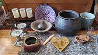Photo showing entire assortment of items including Don Tatebe wood box, pottery, candle sticks, glass vases, decorative pear, mosaic bowl, carnival glass base, and metal flower photo frame arranged on carpeted surface.