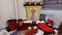 Photo showing a 16-inch celestial fabric angel, metallic candle holders, red Christmas stockings, holiday tea lights, and a Christmas card box on a table.