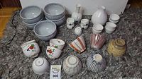 Full lot photo showing all ceramic items on dark textured surface including bowls and sake sets.