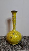 Full view of yellow cloisonné vase with floral design on bulbous base and long neck, showing shape and color