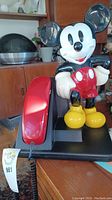 Mickey Mouse vintage rotary phone showing red handset and figure on base.