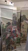Two hanging scrolls side by side: left scroll with palace scene, right scroll with lone figure under umbrella