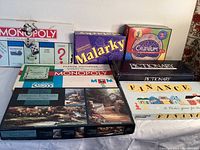 Photo of a stack of classic board games including Monopoly, Malarky, Cranium, Pictionary and Finance.