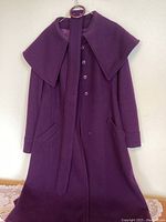 Front of purple women's vintage wool coat showing wide collar, buttons, and waist belt.