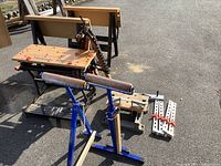 Wide view of the Workmate 400 work table, blue sawhorse with padded rollers, and other sawhorses.