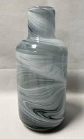 Front view of the 11-inch swirled blown art glass vase showing the overall shape and swirl pattern in gray and white.