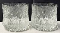 Pair of clear textured glass tumblers side by side showing their design and dimensions.