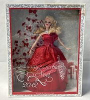 Front view of Barbie doll in original box with holiday-themed background and text.