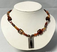 Front view of beaded necklace with sterling silver rectangular pendant showing bead colors and pendant design.