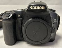 Front view of Canon EOS 30D camera body with lens cap on, showing model and brand.