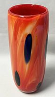 Front and side view of the tall, cylindrical mid-century modern vase showing red-orange swirls and blue oval shapes.