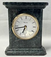 Front view of the vintage Bulova quartz stone mantle clock showing the clock face with Roman numerals and gold-tone bezel.