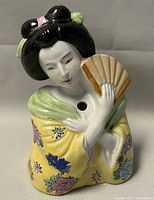 Front view of the vintage hand painted Geisha planter showing facial features, kimono and fan.