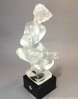 Front angled view of frosted glass nude couple sculpture on black square base showing detail of figures and original sticker on base.