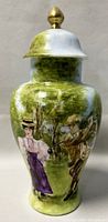 Front view of vintage hand painted lidded urn showing detailed painting of man and woman in period dress against green and blue nature background.