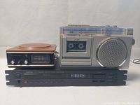 Frontal view showing JVC cassette player with large speaker, Nikko tuner beneath, and brown Wynford Hall unit to left.