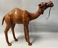Side view of the vintage handmade leather camel statue, showing detailed leather texture and bridle.