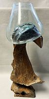 Molten clear glass bowl resting on the root wood stand