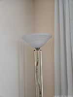 Full view of the brass floor lamp with milky frosted glass shade showing the overall lamp design and height.