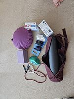 Top-down view of the entire exercise equipment set placed on carpet. Includes yoga mat, cushion, blocks, bands, and fitness accessories packed and unpacked.