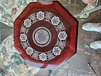 Top view of the octagonal lacquered jewelry box showing intricate white ornamental design on the lid.