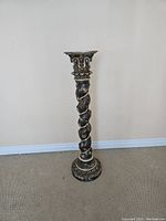 Front full view showing ornate twisted grapevine design up the column, carved base and top with antique dark finish.