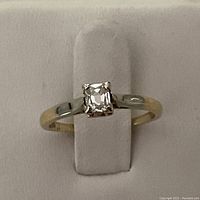 Front-on view showing square diamond set in prongs with two-tone band