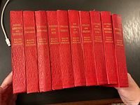 Set of 10 Ralph Waldo Emerson books with red embossed covers, spines showing titles and volume numbers 1-11 with volumes 9 and 12 missing.