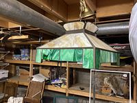 Side view of deco stained glass hanging lamp showing green and beige marbled glass panels and metal frame.