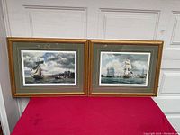 Two framed artist proof prints by Pete Rindlisbacher depicting historic naval scenes. Both have gold gilt wooden frames and green-gray mats with gold accents.
