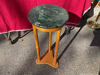 Full view of the wooden plant stand with green marble circular top, showing the marble's veining and wooden legs.