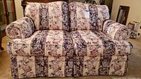 Front view of Broyhill floral print loveseat showing fabric pattern and rolled arms.