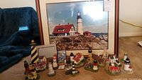 Main lot photo showing framed lighthouse print with 14 lighthouse figurines, 4x6 photo frame, and deck of playing cards