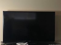 Front view of 60-inch Sharp Aquos TV showing screen and bezel