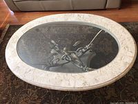 Oblique top view showing oval faux marble-patterned frame and central clear glass inset