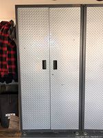 Front view of closed cabinet showing diamond plate doors and recessed handles