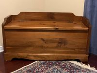 Front view of closed pine storage bench showing natural wood grain and finish.