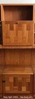 Close-up of cabinet door showing parquet-style teak veneer panels